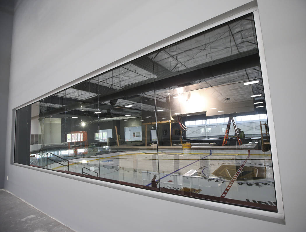 Finishing touches are applied to the ice surface of one of two ice rinks, seen reflected in the window, at City National Arena, the Vegas Golden Knights' headquarters and training facility, in Las ...