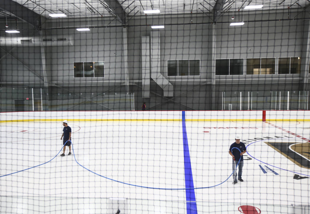 Members of the ice crew put on the finishing touches on the ice surface of one of two ice rinks at City National Arena, the Vegas Golden Knights' headquarters and training facility, in Las Vegas o ...