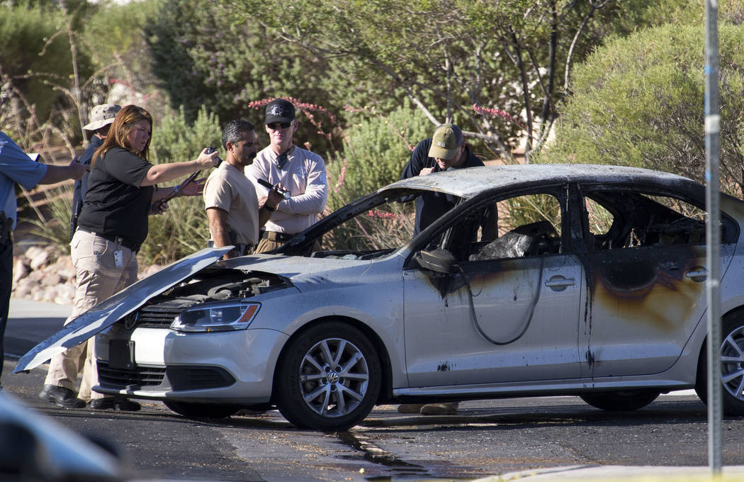 Crime scene personnel and detectives investigate a burned car that contained a body in the 6600 block of Castor Tree Way, near Rainbow Boulevard and Cheyenne Avenue, on Thursday, June 21, 2017. Ri ...