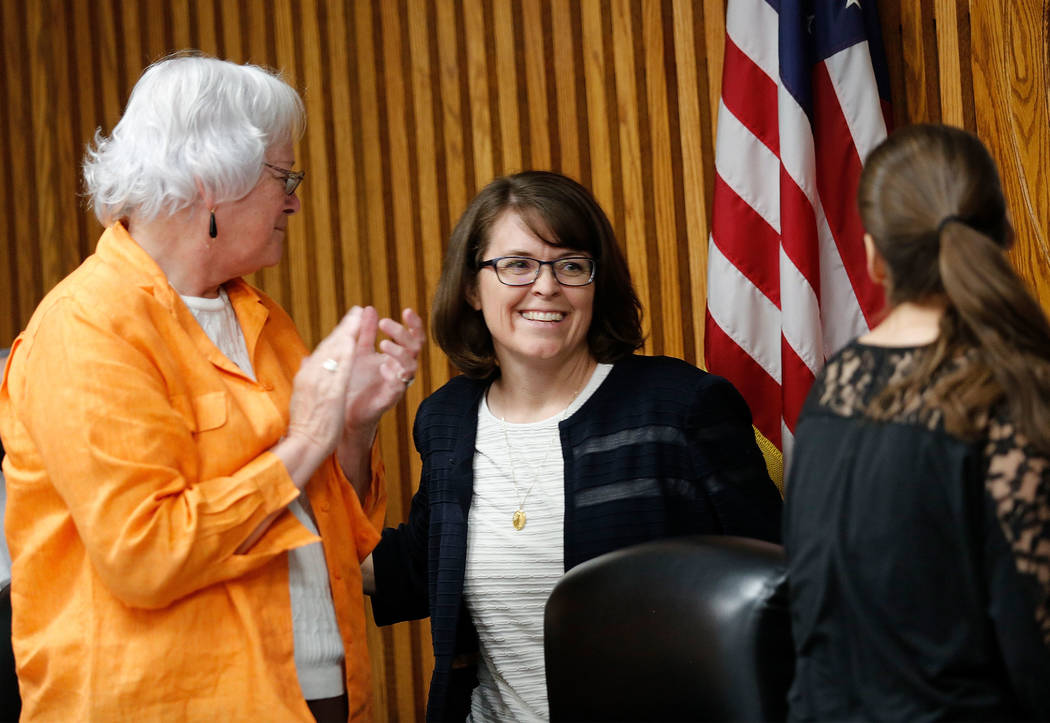 Erin Cranor, center, a member of the Clark County School Board, District G, center, is applauded by other members, Carolyn Edwards, left, and Lola Brooks during her last meeting as a board member  ...
