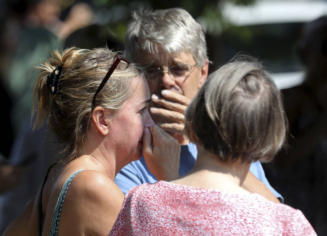 Former Minnehaha Academy employees Elizabeth Van Pilsum, left, and Rick Olson, center, react after an explosion at the school Wednesday, Aug. 2, 2017, in Minneapolis. (David Joles/Star Tribune via AP)