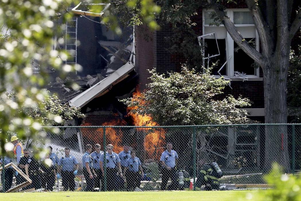 Emergency personnel move away as a gas fire continues to burn following an explosion at Minnehaha Academy Wednesday, Aug. 2, 2017, in Minneapolis. (David Joles/Star Tribune via AP)