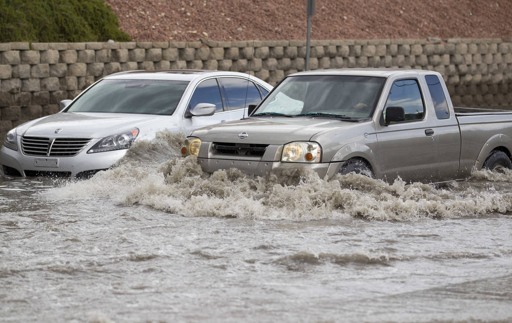 A truck makes its way past a vehicle stalled in flood waters on West Twain Avenue near Dean Martin Drive following rain fall on Friday, August 4, 2017, in Las Vegas. Richard Brian Las Vegas Review ...