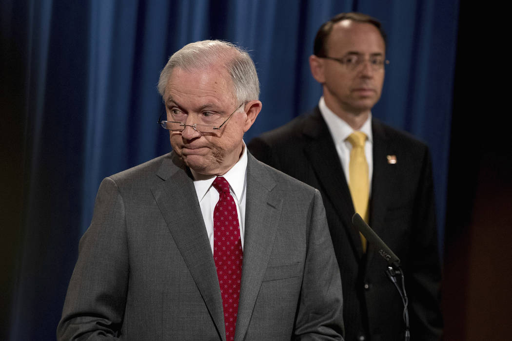 Deputy Attorney General Rod Rosenstein watches at right as Attorney General Jeff Sessions steps away from the podium during a news conference at the Justice Department in Washington, Friday, Aug.  ...