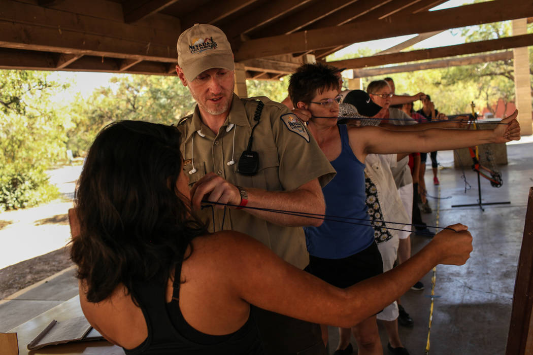 Park Interpreter David Low helps student Xiomara Welsch with a proper shooting position during an archery target shooting program at Spring Mountain Ranch State Park near Blue Diamond on Aug. 25,  ...