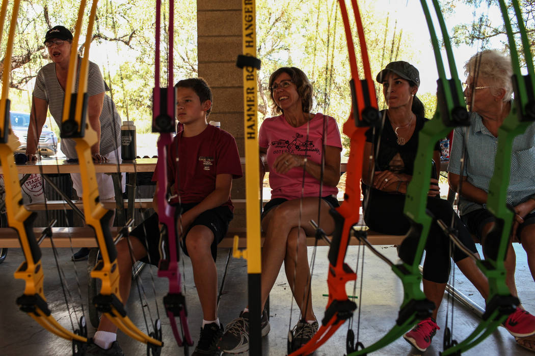 Travis Isennock, 12, from left, Kim Isennock, Raquel Adams and Reena Franze sit as they listen to instructions during an archery target shooting program at Spring Mountain Ranch State Park near Bl ...