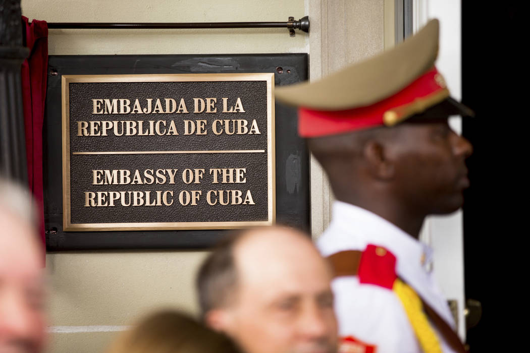In this july 20, 2015 file photo, a member of the Cuban honor guard stands next to a new plaque at the front door of the newly reopened Cuban embassy in Washington. The State Department has expell ...