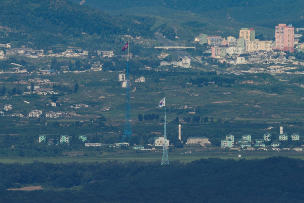A North Korean flag is seen on top of a tower at the propaganda village of Gijungdong in North Korea, as a South Korean flag flutters in the wind in this picture taken near the border area near th ...