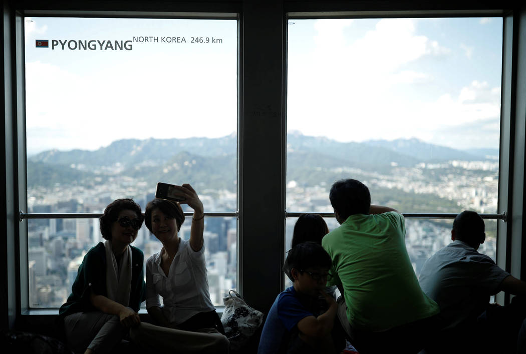 People look at the central Seoul through a window bearing the distance between Pyongyang and Seoul, at an observation platform in Seoul, South Korea, August 11, 2017. (Kim Hong-Ji/Reuters)