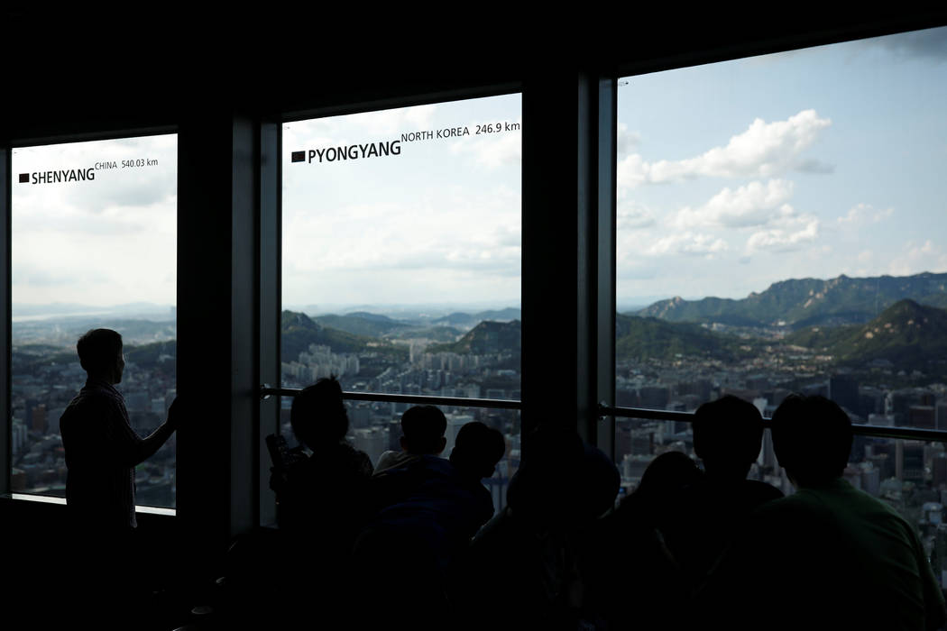 People look at the central Seoul through a window bearing the distance between Pyongyang and Seoul, at an observation platform in Seoul, South Korea, August 11, 2017. (Kim Hong-Ji/Reuters)