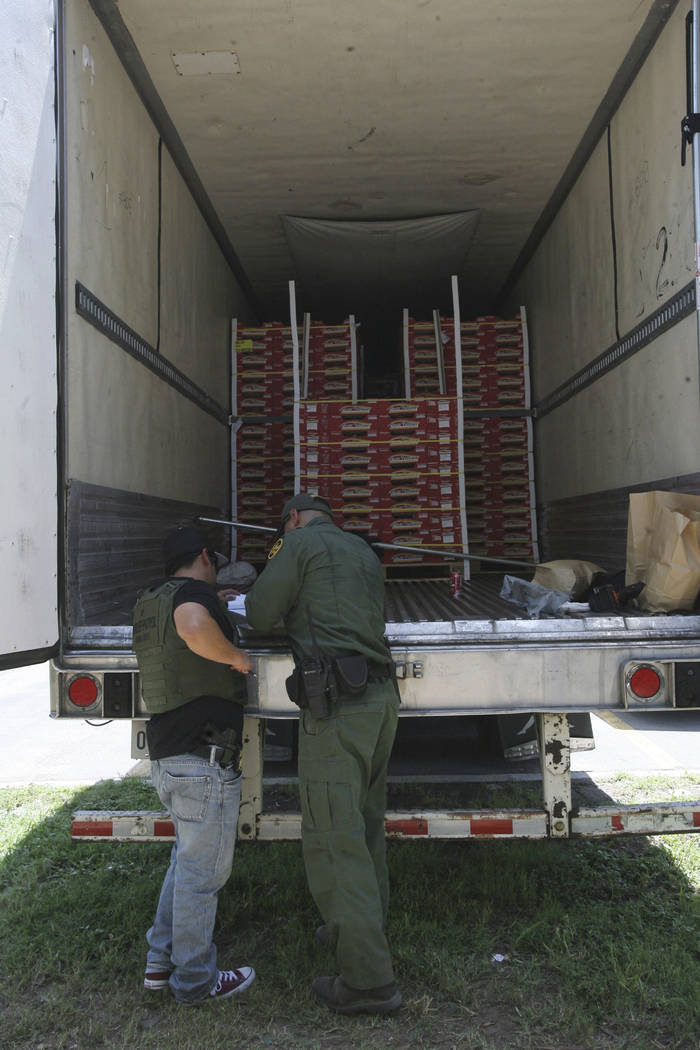 Border Patrol officers check the inside of a tractor-trailer Sunday, Aug. 13, 2017, in Edinburg, Texas. (Delcia Lopez/The Monitor via AP)