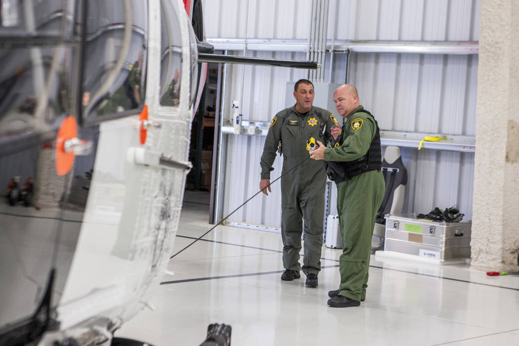 Chief Pilot Steve Morris Jr., center,  and pilot Bryan Woolard prepare the new Las Vegas Metropolitan Police helicopter for flight at the North Las Vegas Airport on Wednesday, Aug. 16, 2017.  Patr ...
