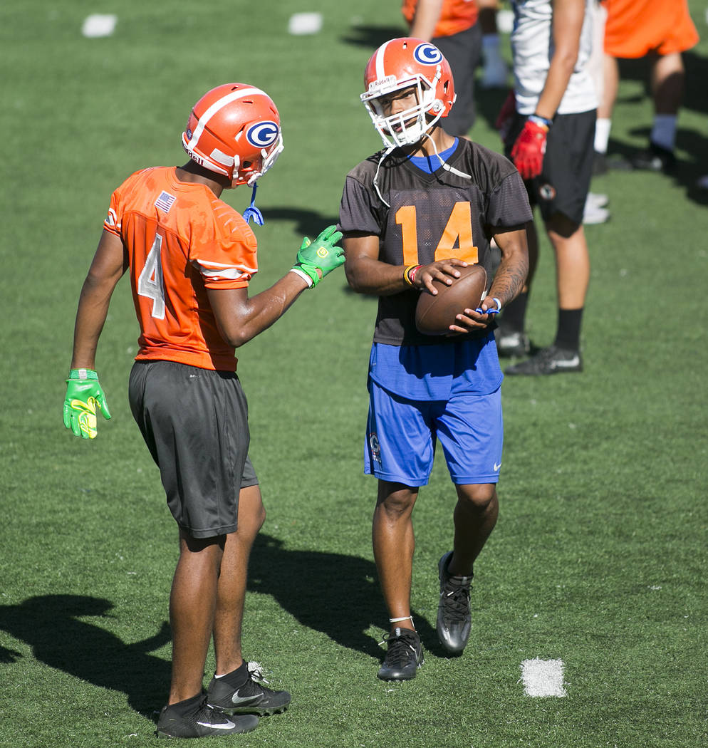 Bishop Gorman quarterback Dorian Thompson Robinson, right, talks with teammate Cedric Tillman during practice at Fertitta Field at Bishop Gorman High School Monday, Aug. 21, 2017, in Las Vegas. Br ...