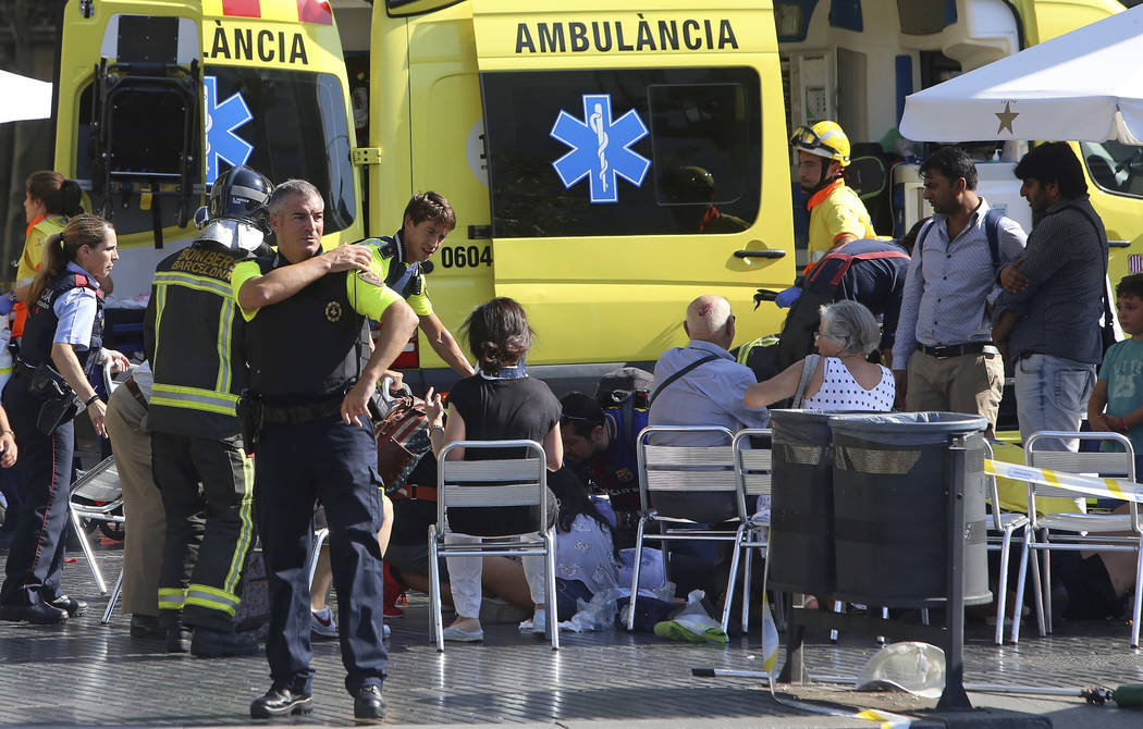 Injured people are treated in Barcelona, Spain, Thursday, Aug. 17, 2017 after a white van jumped the sidewalk in the historic Las Ramblas district, crashing into a summer crowd of residents and to ...