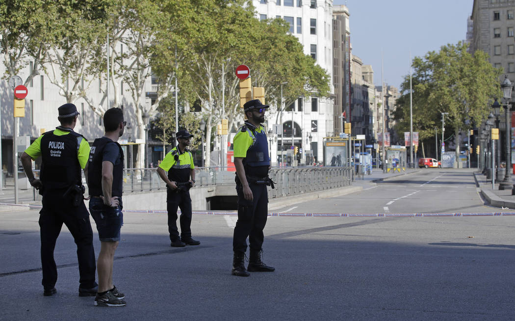 Police officers cordon off a street in Barcelona Thursday, Aug. 17, 2017. Police in the northern Spanish city of Barcelona say a white van has jumped the sidewalk in the city's historic Las Rambla ...