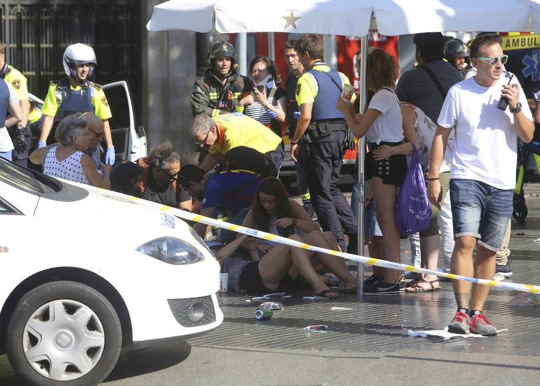 Injured people are treated in Barcelona, Spain, Thursday, Aug. 17, 2017 after a white van jumped the sidewalk in the historic Las Ramblas district, crashing into a summer crowd of residents and to ...