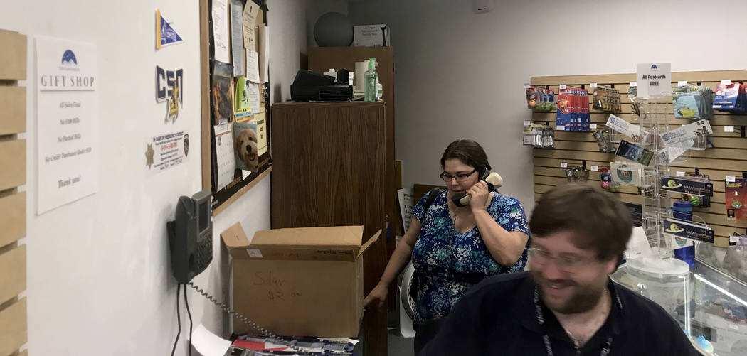Debra Kerr, wife of Planetarium Manager Andrew Kerr, answers phone calls at the gift shop Thursday, Aug. 17, 2017, while her husband helps customers buying solar eclipse glasses. Jessie Bekker Las ...