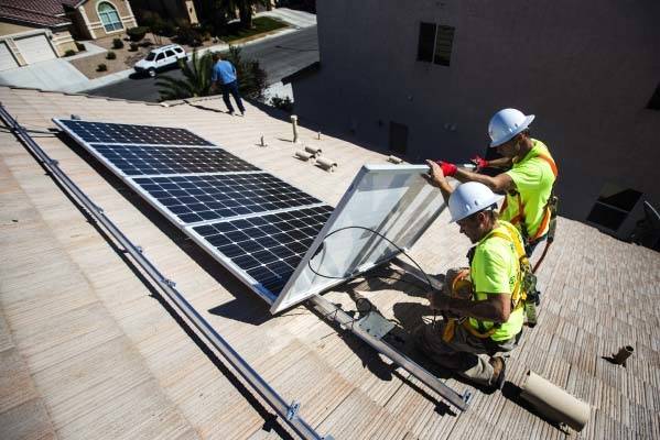 Jacy Sparkman, left, and Matt Neifeld with Robco Electric install solar panels at a home in northwest Las Vegas in 2015. (Jeff Scheid/Las Vegas Review-Journal)