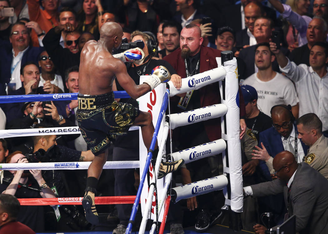 Floyd Mayweather Jr. jumps onto the ropes after defeating Conor McGregor in their super welterweight fight at T-Mobile Arena, Saturday, Aug. 26, 2017, in Las Vegas. Mayweather won via 10th round t ...