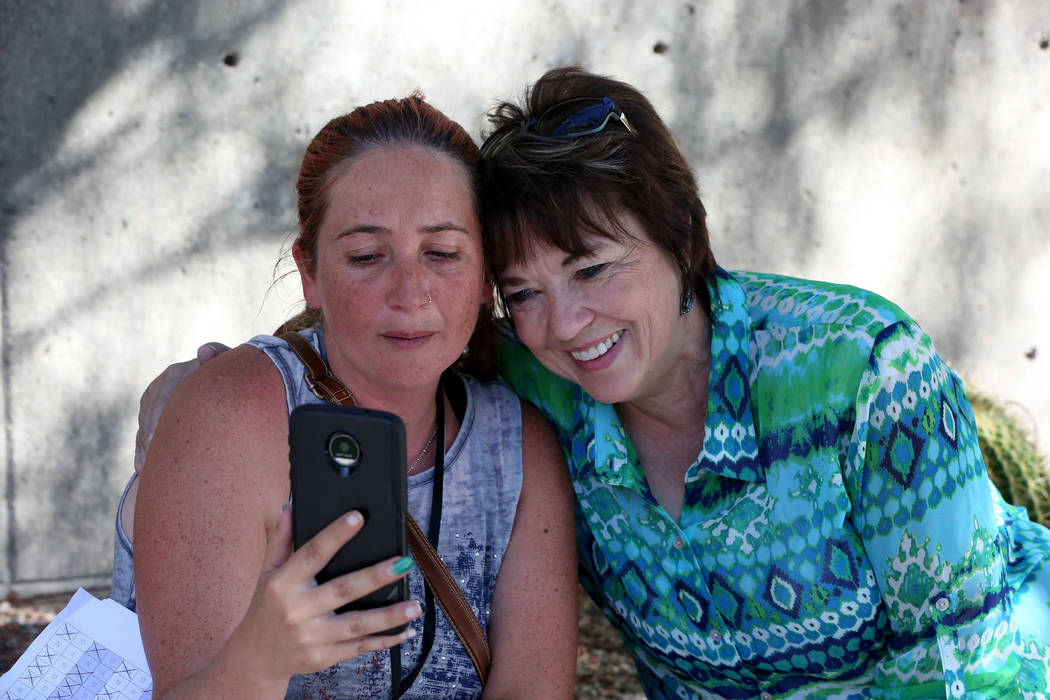 Carol Bundy, right, hugs Andrea Parker, wife of Eric Parker, outside the Lloyd George U.S. Courthouse as she does a live broadcast that her husband and other defendants were found not guilty in th ...