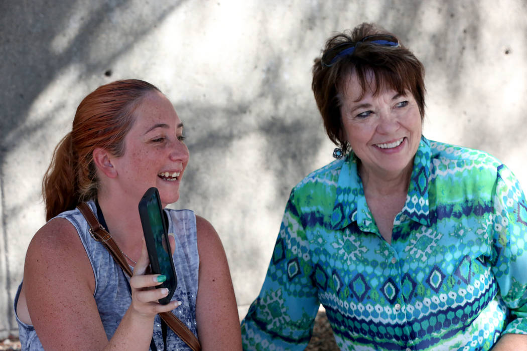 Sitting next to Carol Bundy, Andrea Parker, left, wife of Eric Parker turns her phone to the scene outside the Lloyd George U.S. in Las Vegas during a live broadcast to announce that her husband a ...