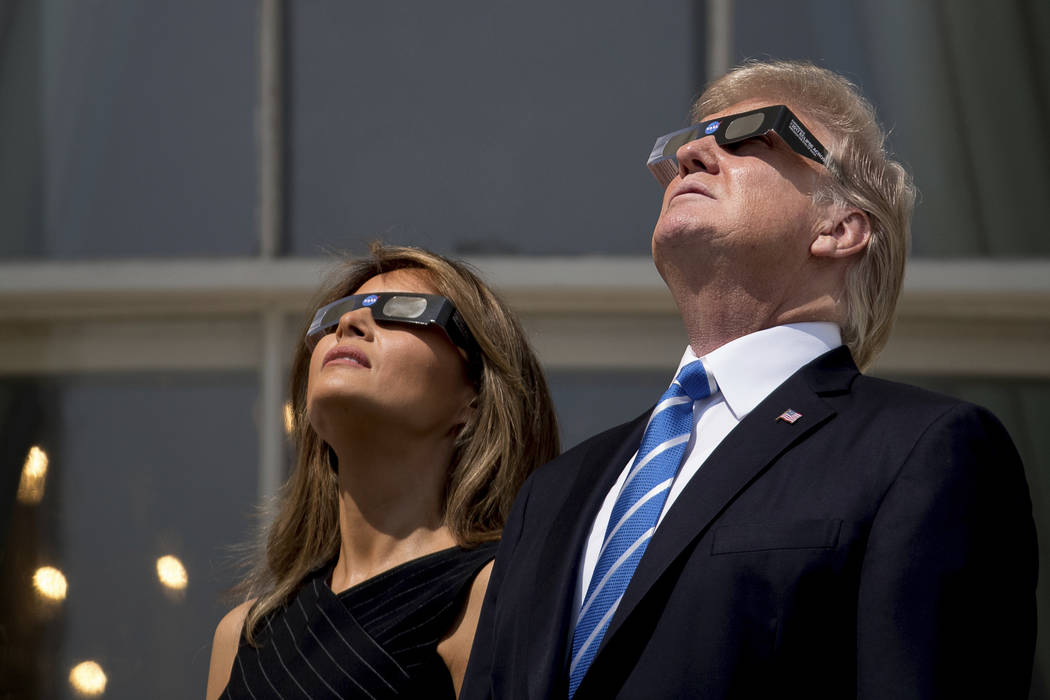 President Donald Trump and first lady Melania Trump wear protective glasses as they view the solar eclipse, Monday, Aug. 21, 2017, at the White House in Washington. (AP Photo/Andrew Harnik)