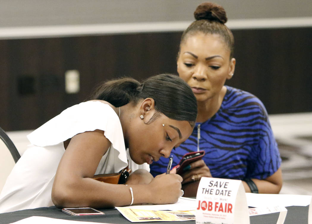 Candice McFarland, left, fills out her job application form as her mother Stephanie looks on during a job fair hosted by the Las Vegas Review-Journal at Palace Station on Thursday, Aug. 17, 2017,  ...