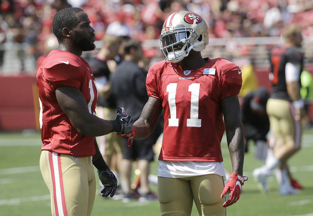 San Francisco 49ers' Pierre Garcon, left, shakes hands with Marquise Goodwin during an NFL football training camp in Santa Clara, Calif., Saturday, Aug. 5, 2017. (AP Photo/Jeff Chiu)