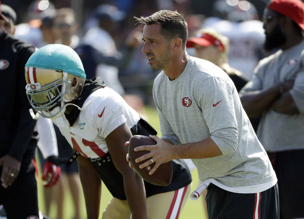 San Francisco 49ers head coach Kyle Shanahan, right, prepares to throw during a joint NFL football practice with the Denver Broncos Wednesday, Aug. 16, 2017, in Santa Clara, Calif. (AP Photo/Marci ...