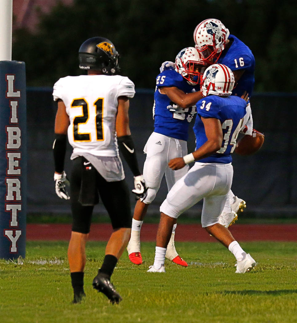 Liberty's Kishon Pitts (25) celebrates his touchdown with his teammates Maurice Hampton (16) and Treyveon Campbell (34) as Saguaro's Brandon Shivers (21) looks on during the second quarter of a fo ...