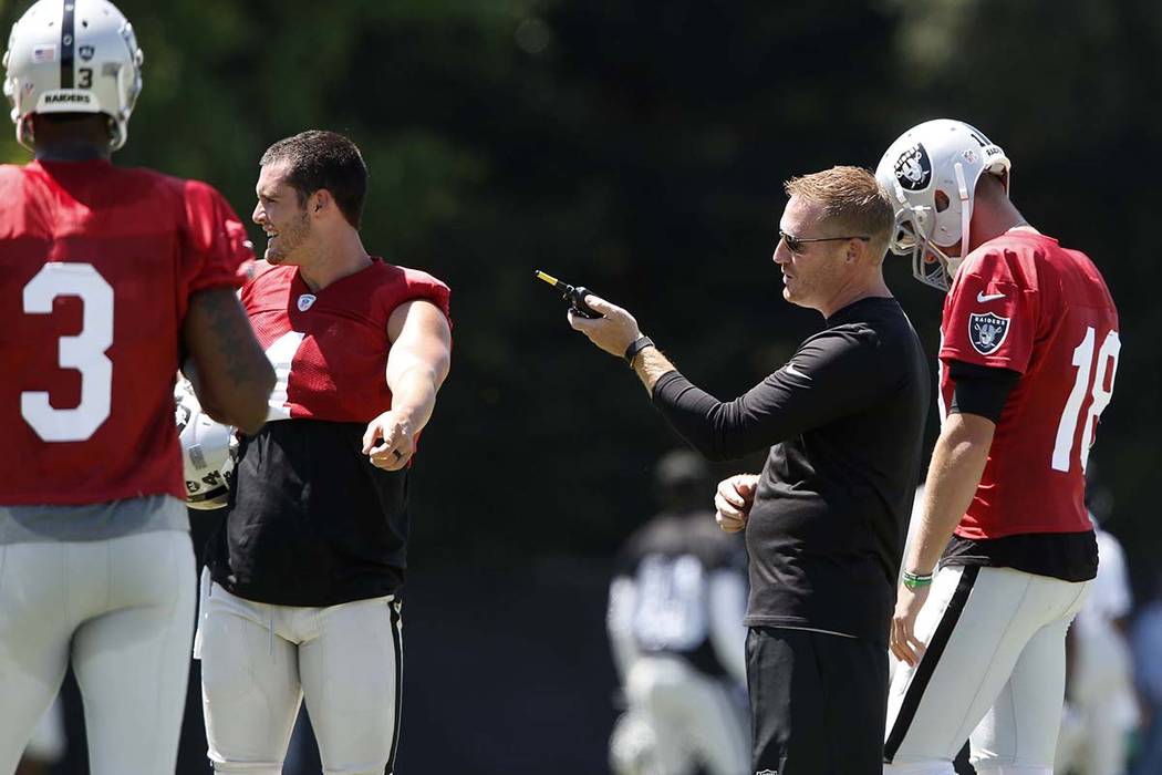 The Oakland Raiders offensive coordinator Todd Downing, second right, talks to back up quarterbacks Ej Manuel (3), Connor Cook (18) and quarterback Derek Carr, second left, during the second day o ...