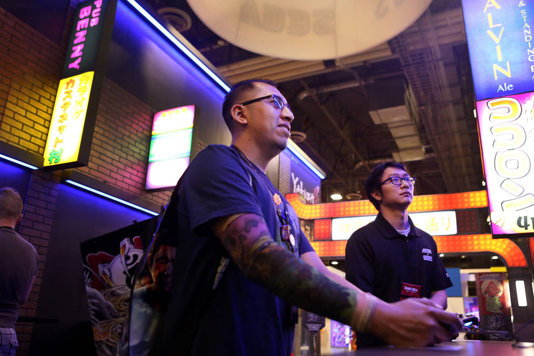 Robert Uck, left, plays Yakuza Kiwami while Jonathan Mac watches during the 2017 GameStop Expo at the Sands Expo and Convention Center, Sunday, Aug. 27, 2017 . Elizabeth Brumley Las Vegas Review-J ...