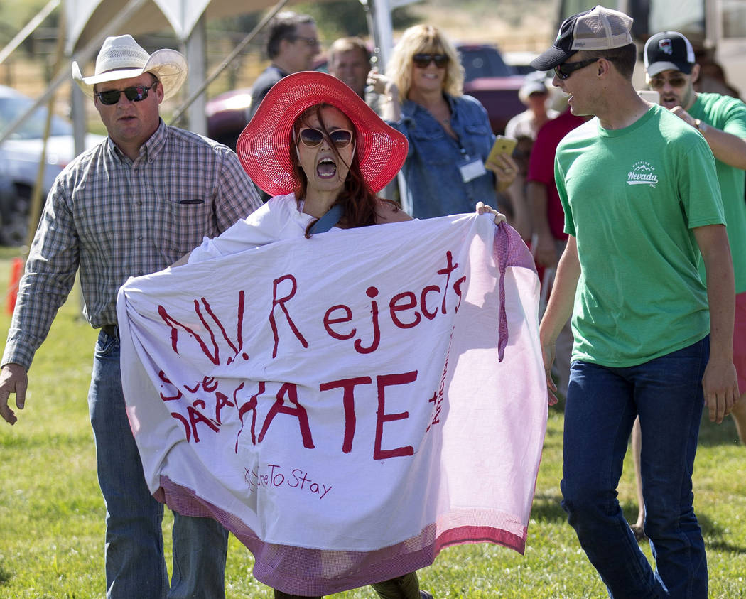Protester Autumn Zemke with Northern Nevada Working Families is escorted out after interrupting Nevada Attorney General Adam Laxalt during the third annual Basque Fry held at Corley Ranch in Gardn ...