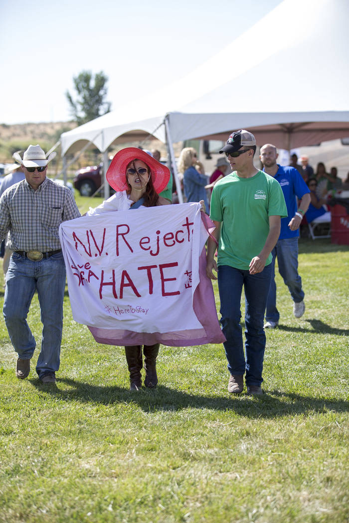Protestor Autumn Zemke, with Northern Nevada Working Families, is escorted out after interrupting Nevada Attorney General Adam Laxalt during the 3rd annual Basque Fry held at Corley Ranch in Gardn ...