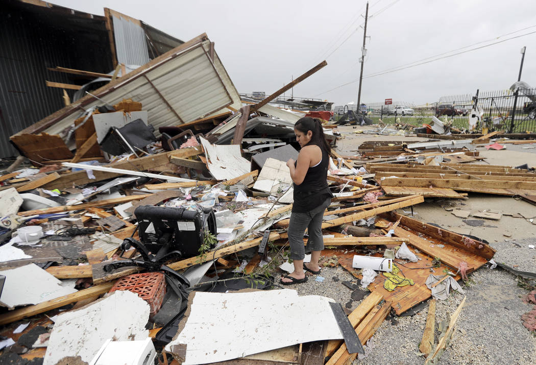 Jennifer Bryant looks over the debris from her family business destroyed by Hurricane Harvey Saturday, Aug. 26, 2017, in Katy, Texas. Harvey rolled over the Texas Gulf Coast on Saturday, smashin ...