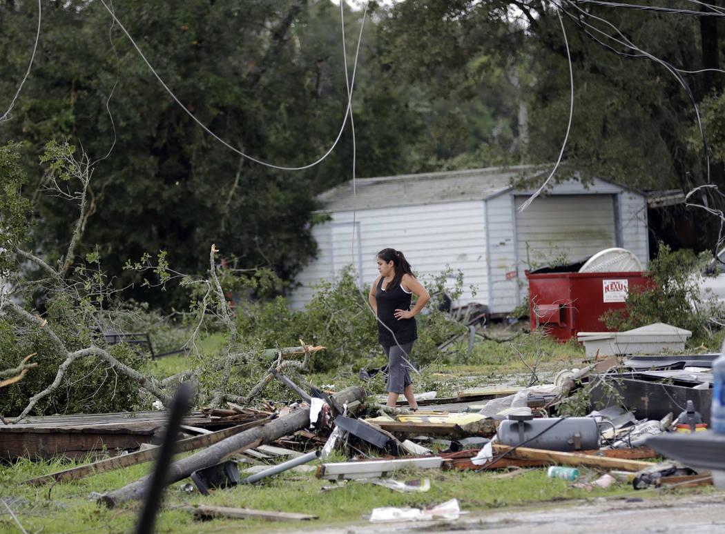 Jennifer Bryant looks over the debris where her family business once stood in the aftermath of Hurricane Harvey Saturday, Aug. 26, 2017, in Katy, Texas. Harvey rolled over the Texas Gulf Coast on ...