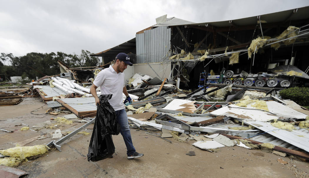 Miguel Debernardis cleans up debris in the aftermath of Hurricane Harvey Saturday, Aug. 26, 2017, in Katy, Texas.   Harvey rolled over the Texas Gulf Coast on Saturday, smashing homes and business ...