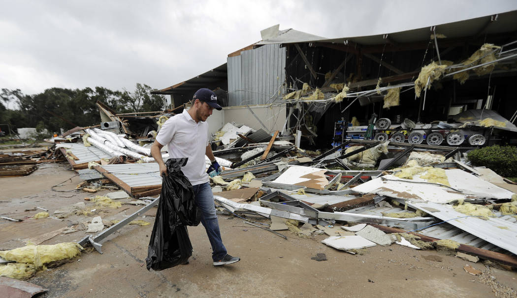 Miguel Debernardis cleans up debris in the aftermath of Hurricane Harvey Saturday, Aug. 26, 2017, in Katy, Texas. Harvey rolled over the Texas Gulf Coast on Saturday, smashing homes and business ...