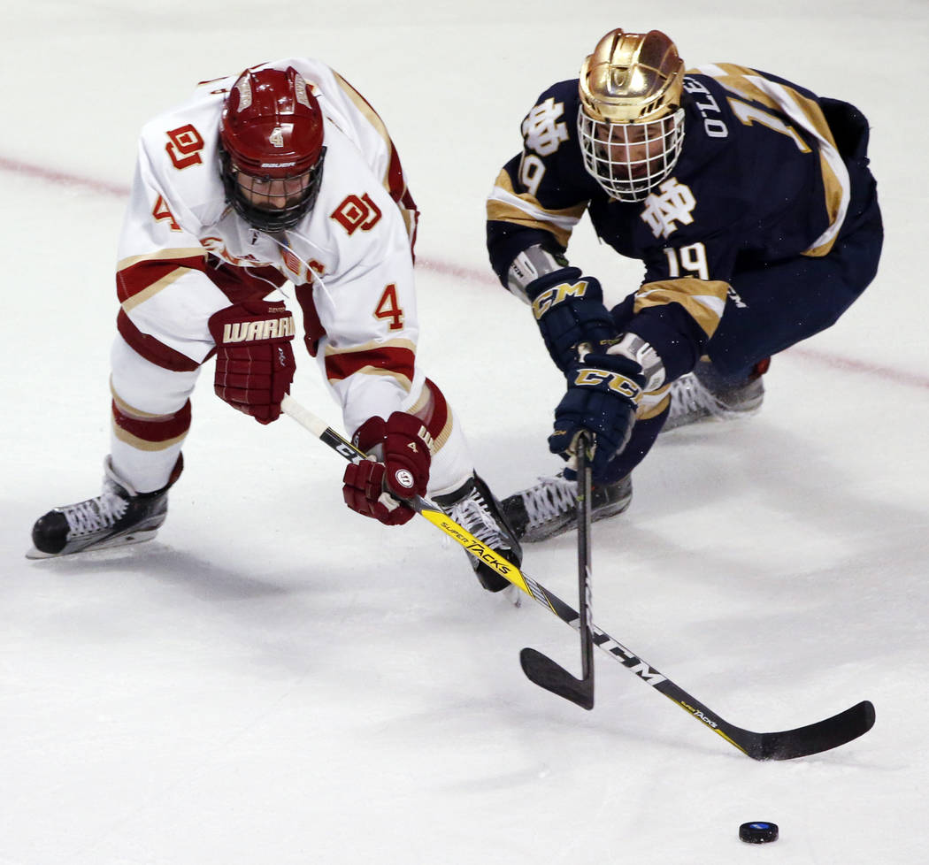 Denver's Will Butcher, left, and Notre Dame's Mike O' Leary vie for the puck during the first period of an NCAA Frozen Four men's college hockey semifinal, Thursday, April 6, 2017, in Chicago. (AP ...