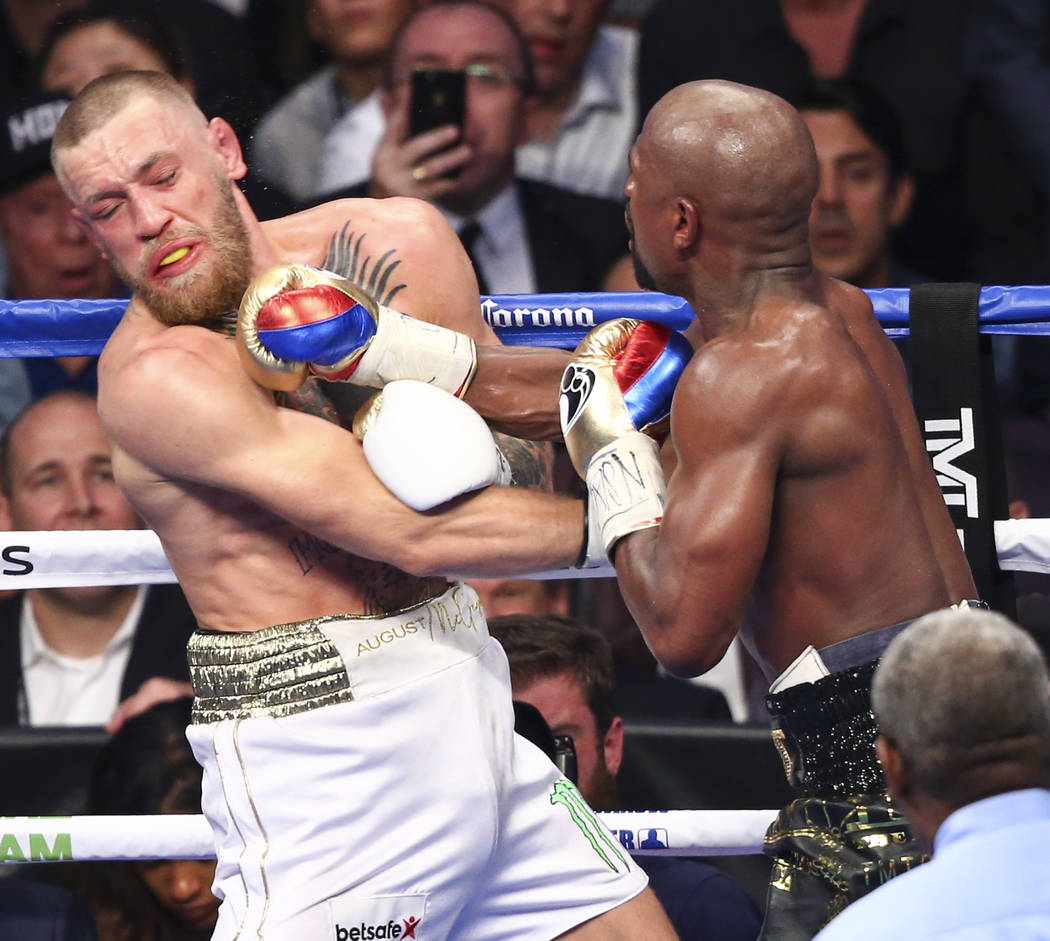 Conor McGregor, left, fights Floyd Mayweather Jr. in their super welterweight fight at T-Mobile Arena, Saturday, Aug. 26, 2017, in Las Vegas. Mayweather won via 10th round technical knockout. Chas ...