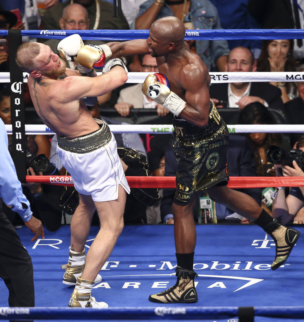 Floyd Mayweather Jr., right, delivers the final blows to Conor McGregor in their super welterweight fight at T-Mobile Arena, Saturday, Aug. 26, 2017, in Las Vegas. Mayweather won via 10th round te ...