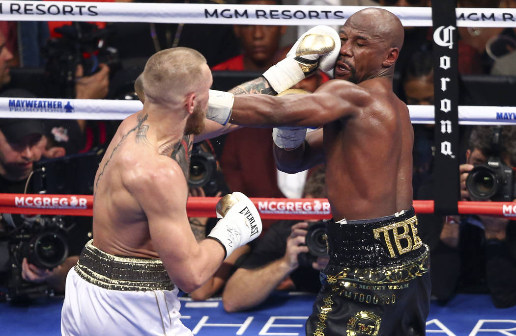 Conor McGregor, left, fights Floyd Mayweather Jr. in their super welterweight fight at T-Mobile Arena, Saturday, Aug. 26, 2017, in Las Vegas. Mayweather won via 10th round technical knockout. Chas ...