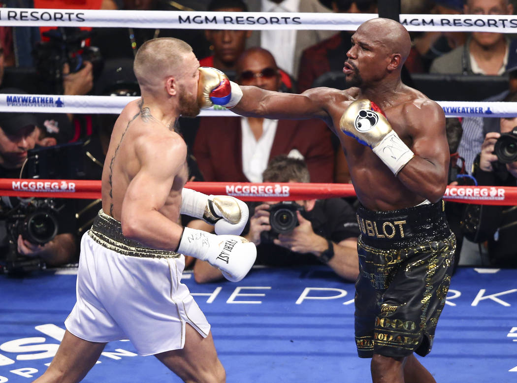 Conor McGregor, left, fights Floyd Mayweather Jr. in their super welterweight fight at T-Mobile Arena, Saturday, Aug. 26, 2017, in Las Vegas. Mayweather won via 10th round technical knockout. Chas ...