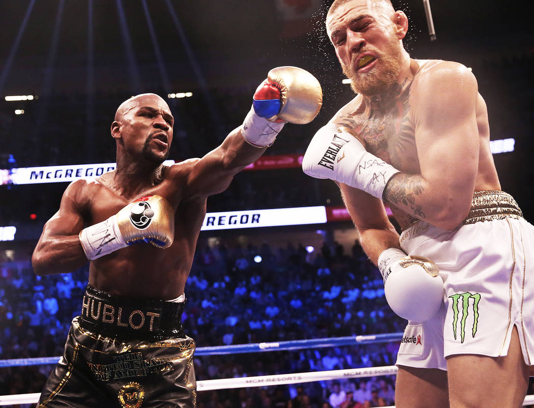 Floyd Mayweather, left, lands a punch against Conor McGregor in the 4th round on Saturday, Aug 26, 2017, at T-Mobile Arena, in Las Vegas. Benjamin Hager Las Vegas Review-Journal @benjaminhphoto