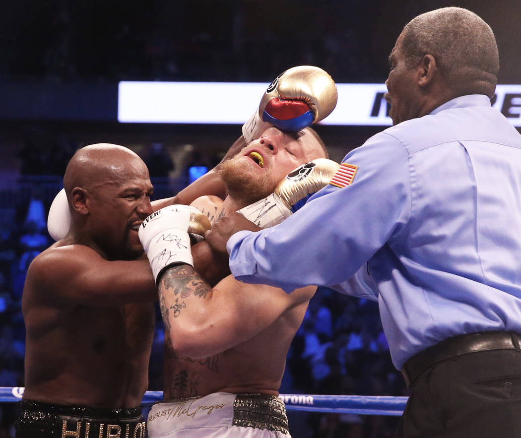 Floyd Mayweather, left, gets tied up with Conor McGregor on Saturday, Aug 26, 2017, at T-Mobile Arena, in Las Vegas. Benjamin Hager Las Vegas Review-Journal @benjaminhphoto