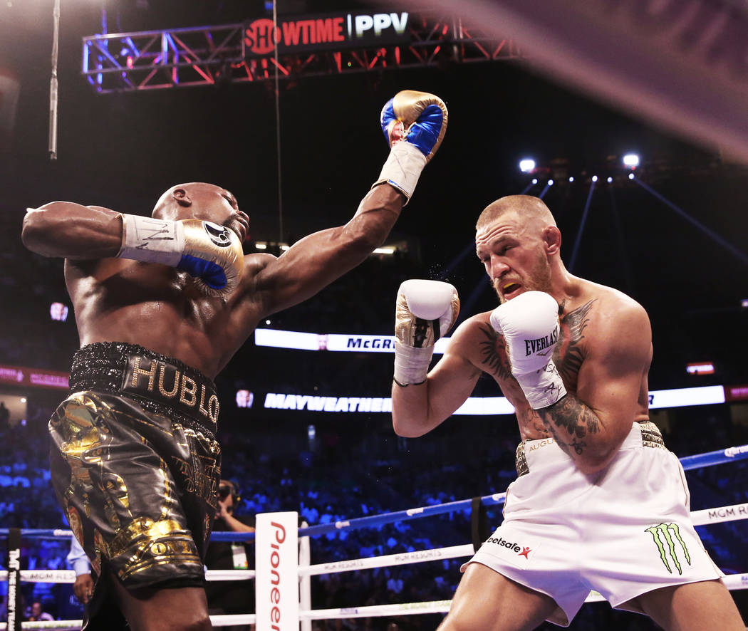 Floyd Mayweather, left, lands a punch against Conor McGregor in the blank round on Saturday, Aug 26, 2017, at T-Mobile Arena, in Las Vegas. Benjamin Hager Las Vegas Review-Journal @benjaminhphoto
