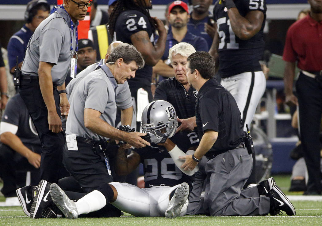 Oakland Raiders cornerback David Amerson (29) is checked on by team medical staff after suffering an unknown injury in the first half of a preseason NFL football game against the Dallas Cowboys on ...