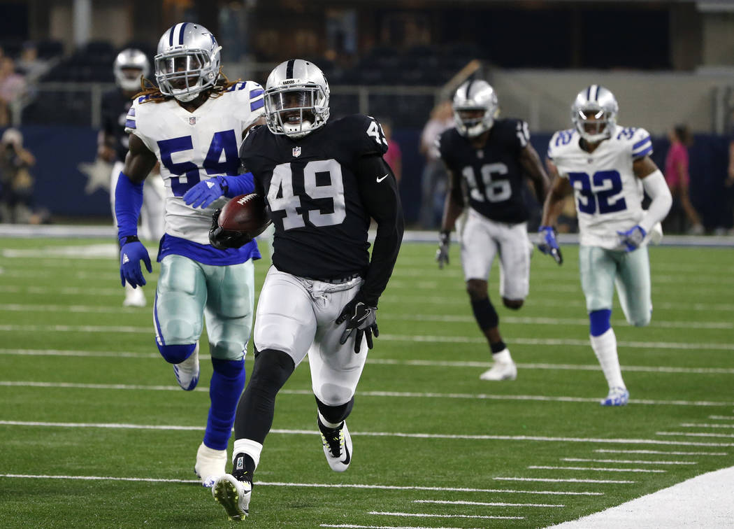Oakland Raiders fullback Jamize Olawale (49) reaches for his left leg as he heads to the sideline after returning a punt as Dallas Cowboys linebacker Jaylon Smith (54) gives chase in the first hal ...