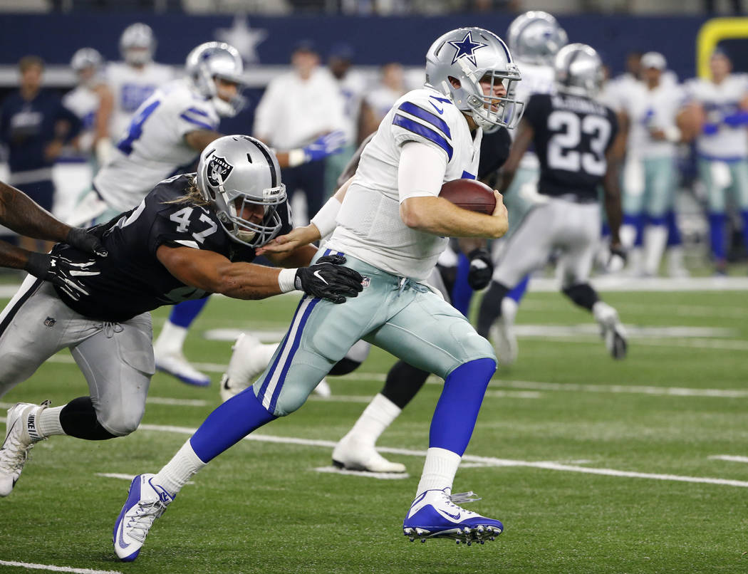 Dallas Cowboys quarterback Cooper Rush (7) runs the ball for a first down as Oakland Raiders linebacker James Cowser (47) attempts the stop in the second half of a preseason NFL football game, Sat ...