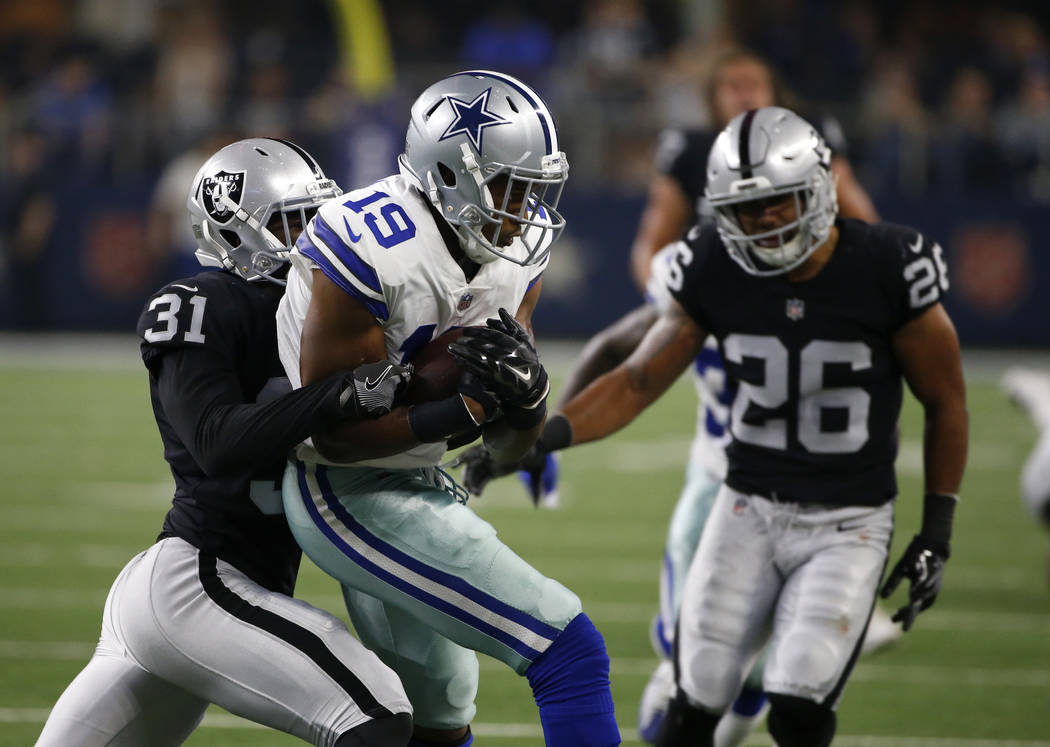 Oakland Raiders' Breon Borders (31) and Shalom Luani (26) stop Dallas Cowboys wide receiver Brice Butler (19) after Butler caught a pass in the second half of a preseason NFL football game, Saturd ...